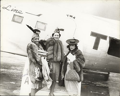 Mrs. Joe Louis and two friends standing before TWA plane