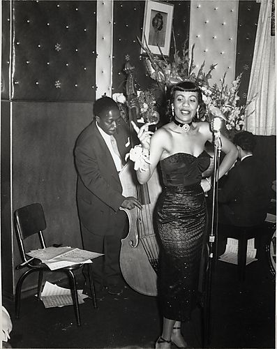 Singer Tish Goode at microphone, with bass player William Bass" McMahon, and piano players at the Flamingo Club in the Hill"