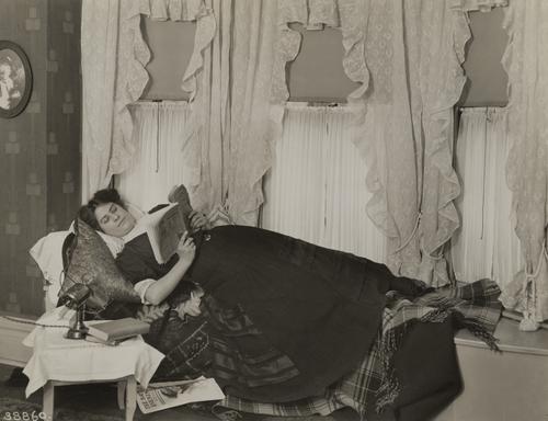 Woman using a fan while reading
