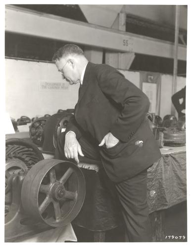 W.S. Rugg examining induction motor at exhibit for Ford Museum