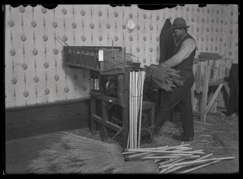 Blind man assembling brooms