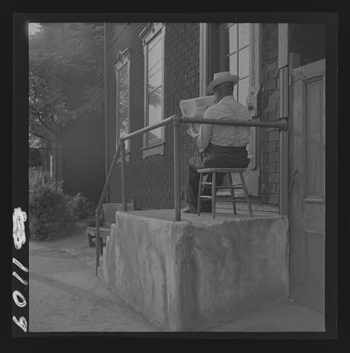 Man Reading Newspaper on Steps